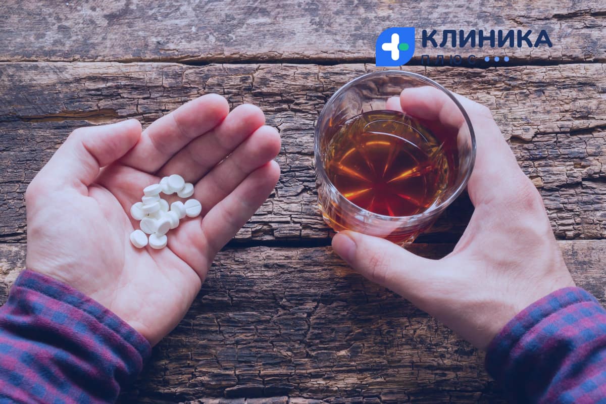 Человек держит таблетки и алкоголь 